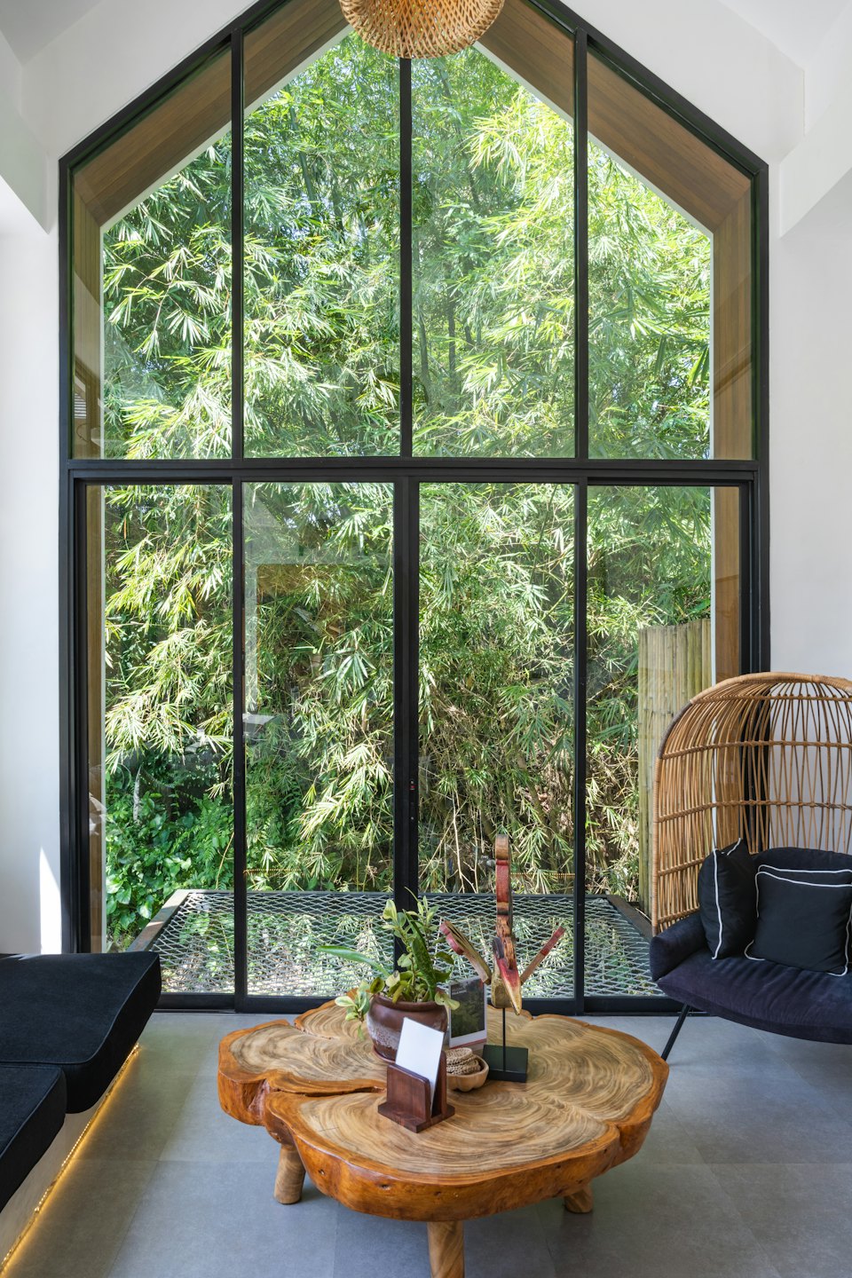 Modern lounge with large window overlooking bamboo forest.