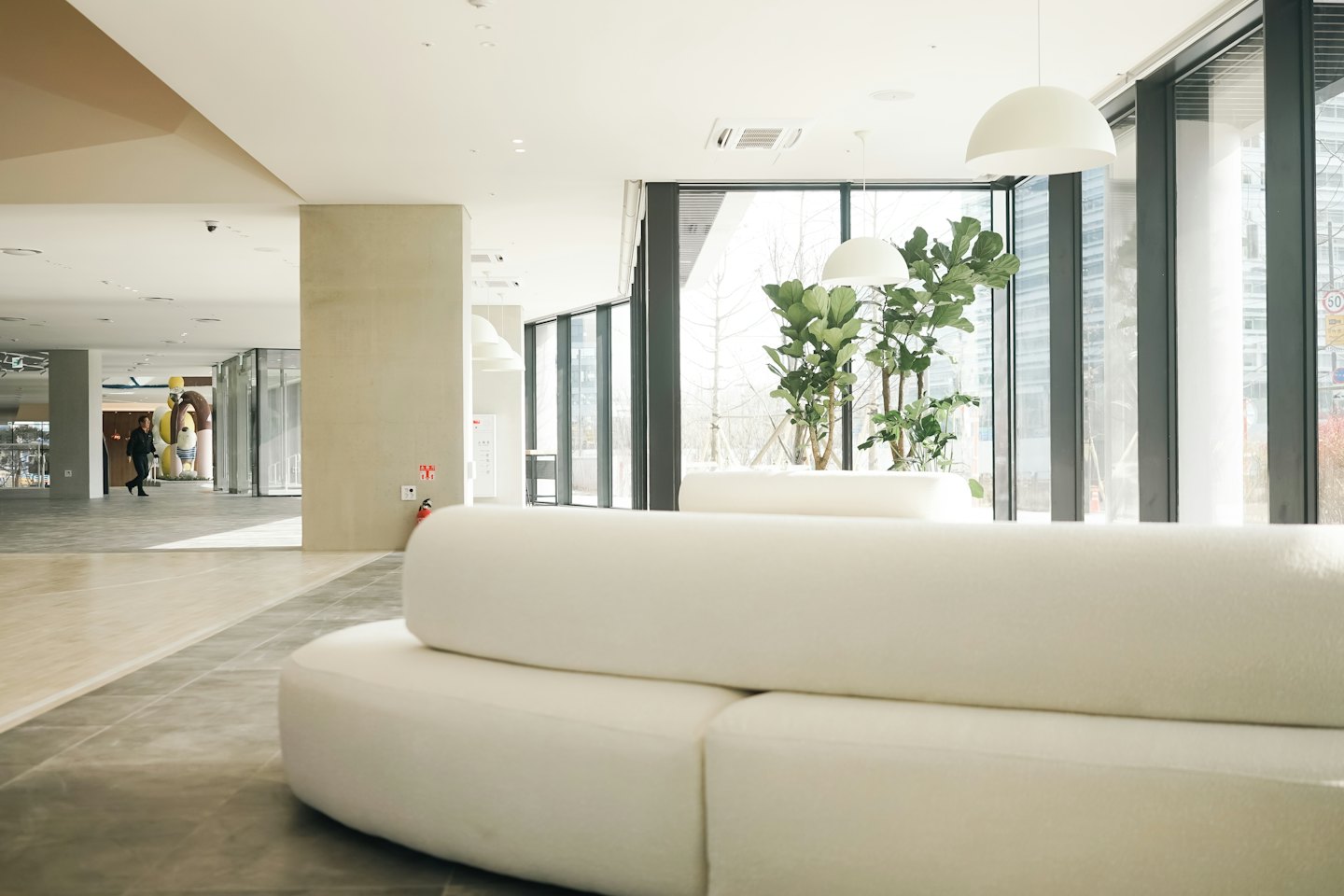 Modern lobby with curved sofas and large windows.